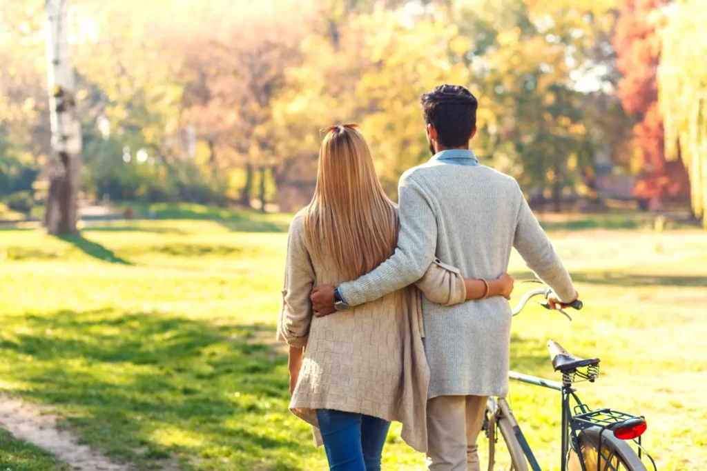 couple with bicycle walking in park on sunny autum utc